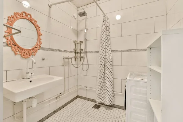 壁に白いタイルと黒と白のタイルのバスルームにはシンク トイレ 鏡とシャワーがあります — ストック写真