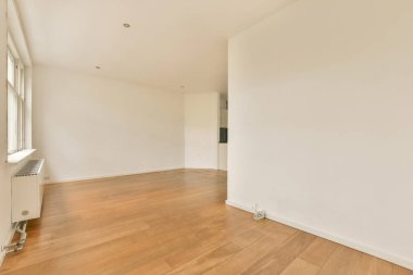 Odasında ahşap döşeme ve beyaz duvarlar olan boş bir oda çok temiz, ama ışık yok.