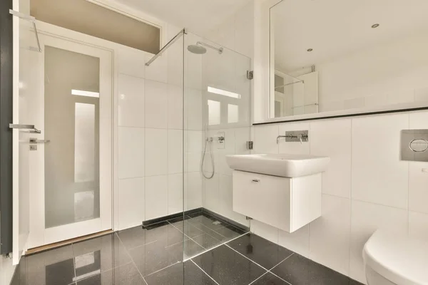 黒と白のタイル張りの床とモダンなバスルーム角のガラスシャワーストールドアとトイレ — ストック写真