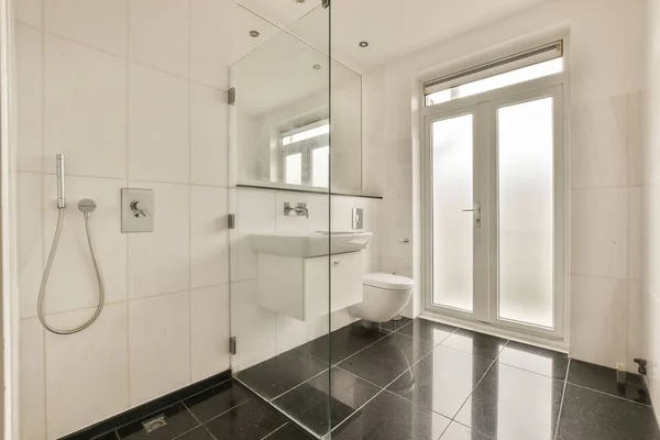 Moderní Koupelna Černou Bílou Dlážděnou Podlahou Skleněnými Sprchovými Dveřmi Rohu — Stock fotografie