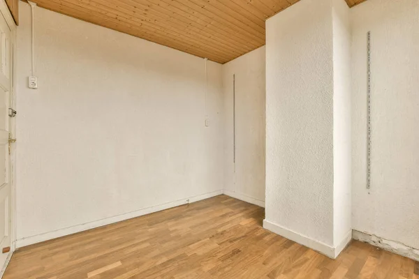 壁に白い壁と木の床がある空の部屋 角にドアがあります — ストック写真
