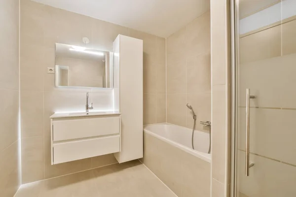 浴槽の横に洗面台とバスタブ付きのバスルーム鏡の前の壁に — ストック写真