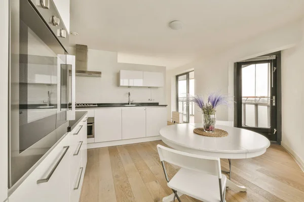 Una Cocina Comedor Apartamento Moderno Con Armarios Blancos Suelos Madera —  Fotos de Stock