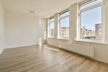 boş bir oda ahşap döşeme ve geniş pencereli bu fotoğraftaki şehir fotoğraflarına bakan içeriden çekilmiş.