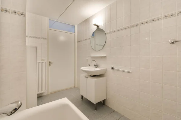 在墙面镜子旁边的角落里有洗澡间和洗澡盆的浴室是敞开着的门 — 图库照片