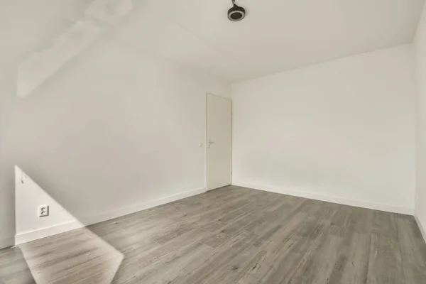 房间是一个有白色墙壁和木制地板的空房间 房间很干净 随时可用来储存 — 图库照片