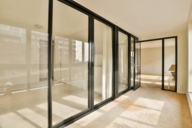 Yeni bir apartmanda, Londra 'da, İngiltere' de cam kapılar ve tavan pencereleri olan boş bir oda.