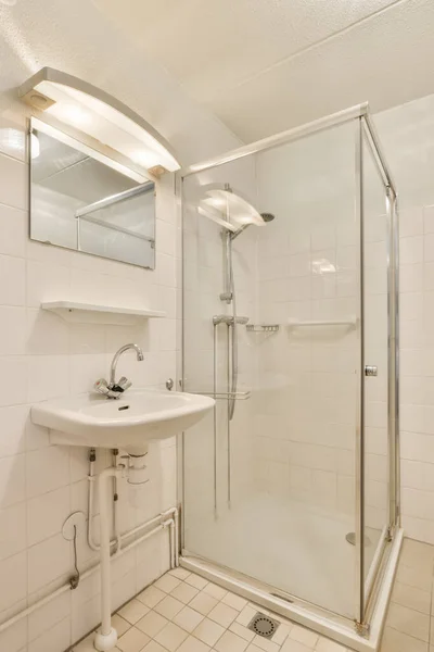 部屋の左側の角に洗面台と鏡とシャワーストール付きの浴室 — ストック写真
