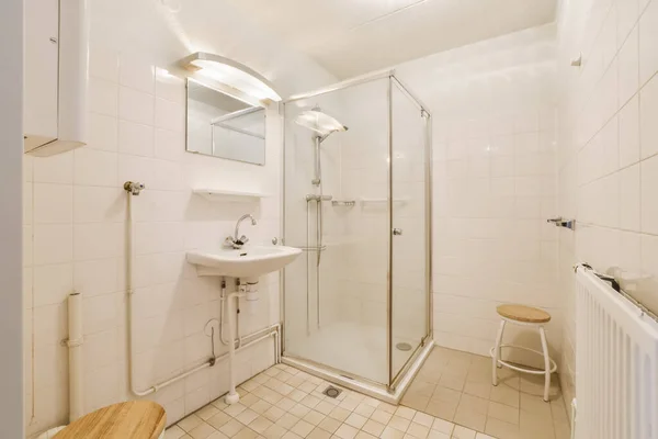 部屋の左側の角に洗面所とトイレとシャワーストール付きの浴室があり — ストック写真