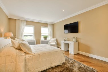 Duvarında televizyon olan bir yatak odası ve duvara monte edilmiş düz ekran bir televizyonun önünde büyük bir yatak.