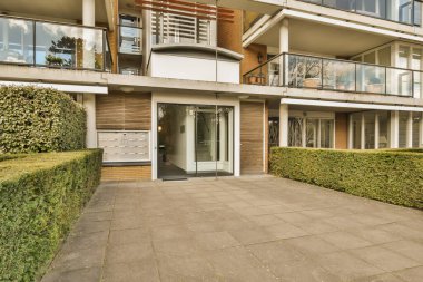 Evin her iki tarafında da bitkiler ve çalılar olan bir evin dışında, iki balkon dahil.