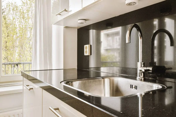 Eine Küche Mit Arbeitsplatten Aus Schwarzem Granit Und Weißen Schränken — Stockfoto