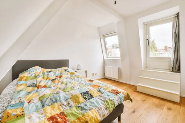 Ein Bett Einem Zimmer Mit Holzboden Und Weißen Wänden Gibt — Stockfoto