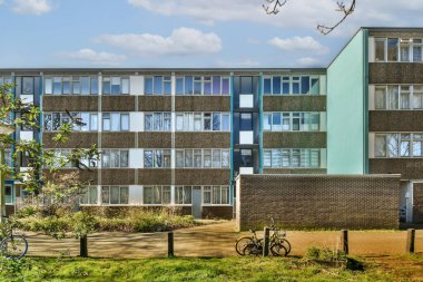 Önündeki kaldırımlarda bisikletleri olan bir apartman kompleksi ve soldaki bazı binalar.