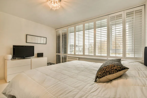 一间卧室 房间里有白色的床上用品 窗户很大 可以俯瞰城市的景观 — 图库照片