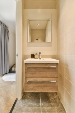 Yanındaki duvarda lavabo, ayna ve tuvalet kağıdı olan bir banyo açık bir duş kabini.