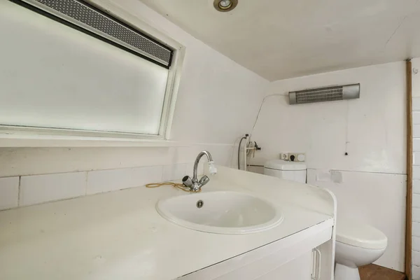 stock image a bathroom with a white sink and toilet in the corner, which is being used as a shower room for people to use