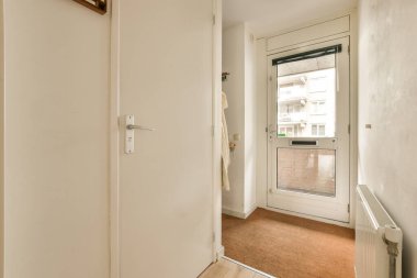 Beyaz duvarları ve ahşap döşemeleri olan boş bir oda sağ tarafta açık, pencerede bir pencere var.