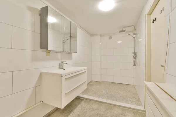 白いタイルの壁と床のあるバスルームシャワーエリアは壁に2つの大きな鏡で区切られています — ストック写真