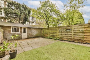 Çitli bir arka bahçe ve ön taraftaki bazı bitkiler - açılı bir perspektiften görüntü alınır