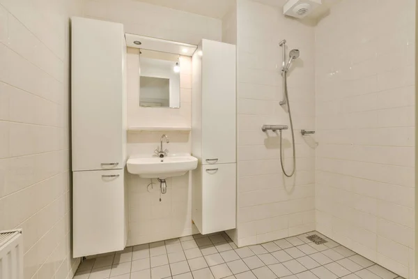 地板上有白色瓷砖和墙壁的浴室 包括水池 淋浴间和毛巾架 — 图库照片