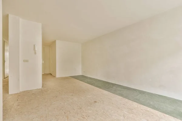 右边是一个有白色墙壁和绿色地板的空房间 中间有一扇门 — 图库照片