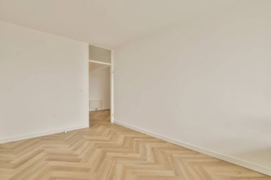 Odanın ortasında beyaz duvarları ve parke ahşap zemini olan boş bir oda çok temiz.