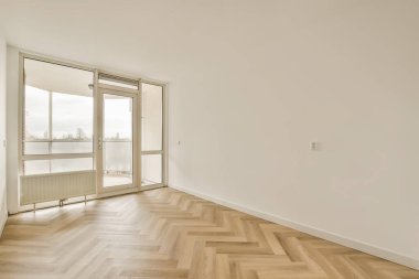 Ahşap zeminleri ve beyaz duvarları olan boş bir oda. Oturma odasından balkona kadar sokağa bakıyor.