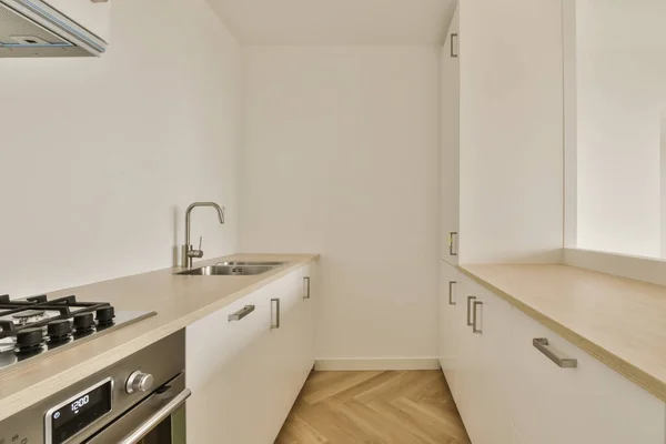 stock image a kitchen with white cabinets and wood counter tops in an apartment near london, england by corbo architects
