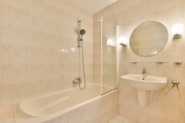 横の壁には洗面器と鏡とバスタブ付きの浴室があります — ストック写真