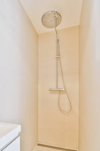 シャワースタンドにはシャワーヘッドと手を備えたバスルームがあります — ストック写真