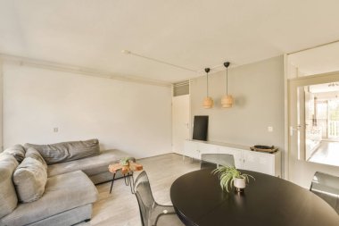 Odanın ortasında kanepesi, masası ve televizyonu olan bir oturma odası var.