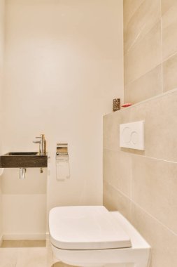 Tuvaleti, lavabosu ve aynası olan bir banyo. Duvarın köşesinde beyaz fayans var.