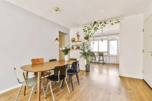 床に白い壁と木の床と堅木の床を持つ部屋のダイニングテーブルと椅子 — ストック写真