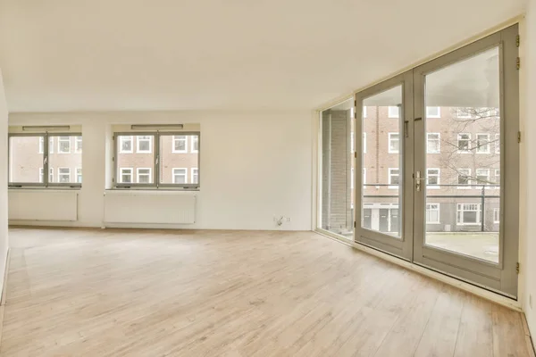 Ein Leeres Wohnzimmer Mit Holzboden Und Glasschiebetüren Die Zum Balkonbereich — Stockfoto