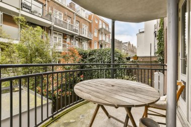 Bir balkon, açık masa ve dairelerin önünde sandalyeler, balkon, Londra.