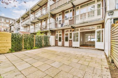 Arka planda bazı bitki ve binalar olan bir dış alan, yerden binaya bakarken görüldüğü gibi.