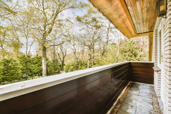 stock image an outside area with trees and plants on the side of a house that has been gutted by water damage