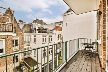 Sandalyeli, masalı bir balkon ve apartmanların çatı katında bir açık hava yemek seti.