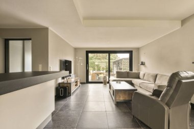 Kapının önünde iki kanepesi ve bir sehpası olan bir oturma odası.