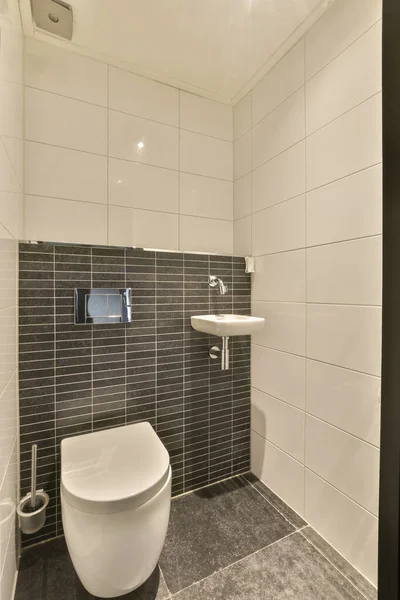 Ein Badezimmer Mit Schwarzen Und Weißen Fliesen Den Wänden Toilettenschüssel — Stockfoto