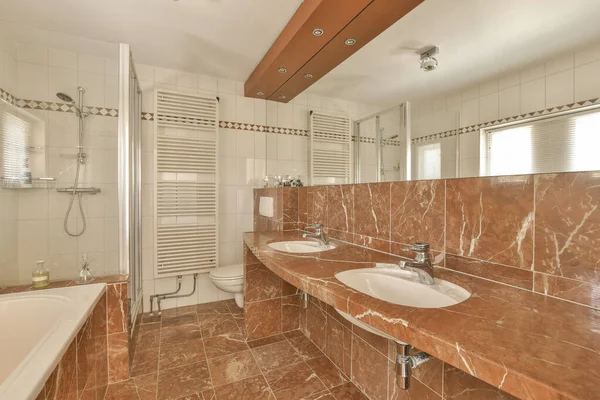 stock image a bathroom with marble flooring and white tiles on the walls, along with a bathtub in the corner