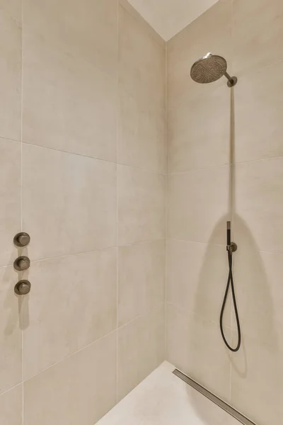 하얀색 타일로 두르고 샤워를 벽에는 손으로 샤워기의 머리가 있습니다 — 스톡 사진