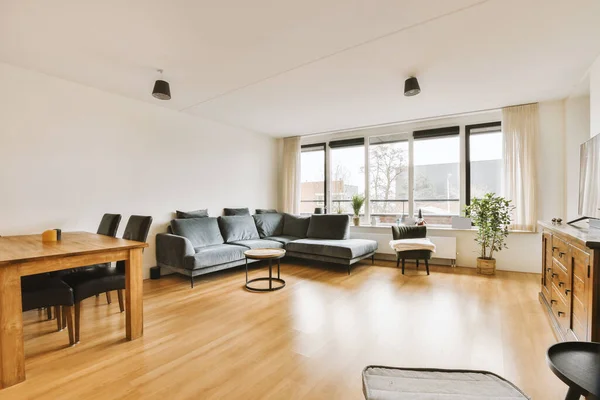 Ruang Tamu Dengan Lantai Kayu Dan Dinding Putih Termasuk Meja — Stok Foto