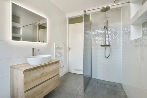 横の壁にはシンク鏡とシャワーヘッドが設置された浴室は木の虚栄心です — ストック写真