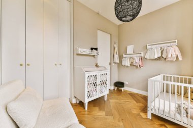 Köşesinde bir bebek odası ve yerde beyaz bir cırcır böceği olan bir oda.