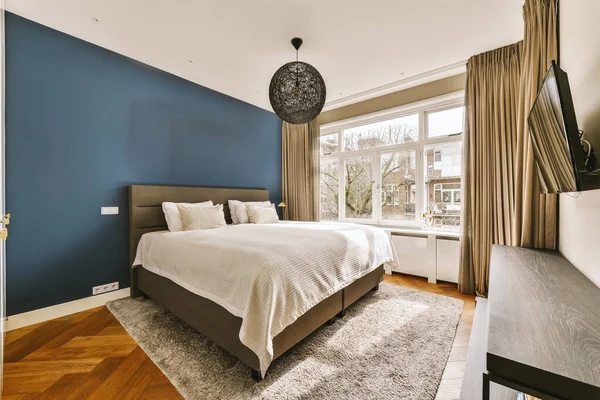Een Slaapkamer Met Houten Vloeren Een Blauwe Accentwand Achter Het — Stockfoto