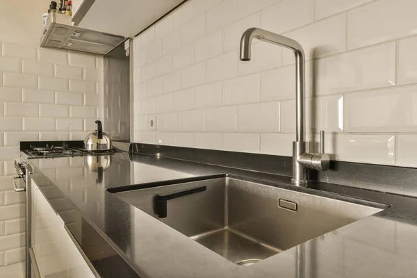 Kitchen Sink Middle White Tiled Wall Black Countertop Stainless Fauced — Stock Photo, Image