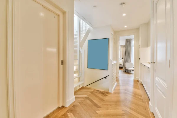 a hallway with hardwood flooring and white trim on the walls in an apartment or townhouse, taken from above