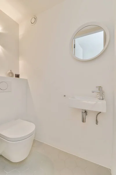 Bílá Koupelna Umyvadlem Před Kulatým Zrcadlem Zdi Ním Malé Okno — Stock fotografie